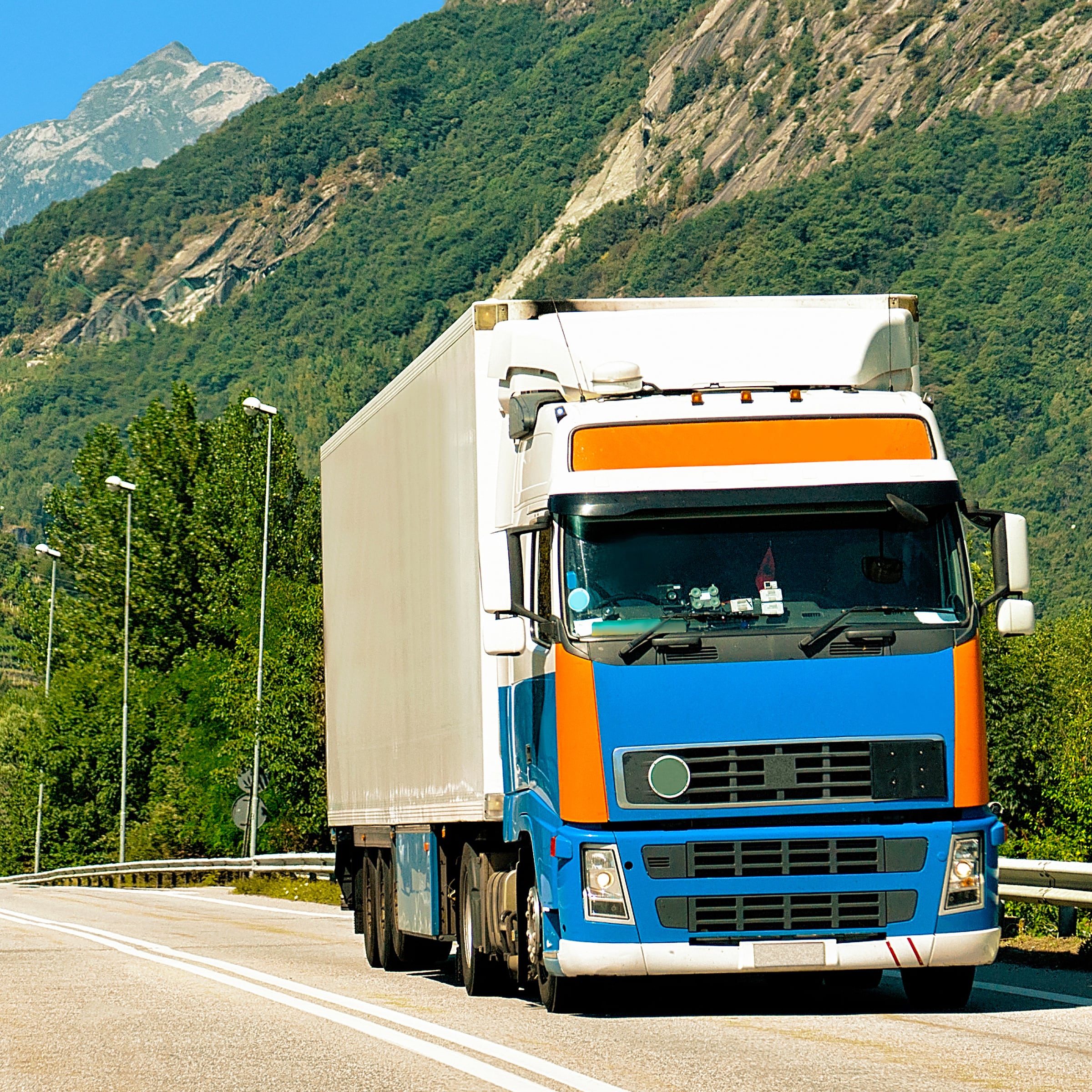 truck-summer-road-switzerland-trucker-highway-lorry-doing-logistics-work-semi-trailer-with-driver-big-cargo-car-drive-freight-delivery-transport-export-industry-container-with-goods (1)-min